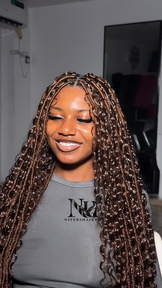 Long dark faux locs with light accents frame a smiling woman’s face