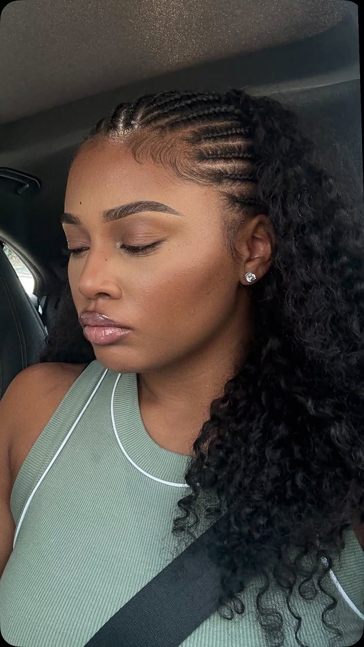 Woman with cornrows and long voluminous curly crochet braids seated in a car