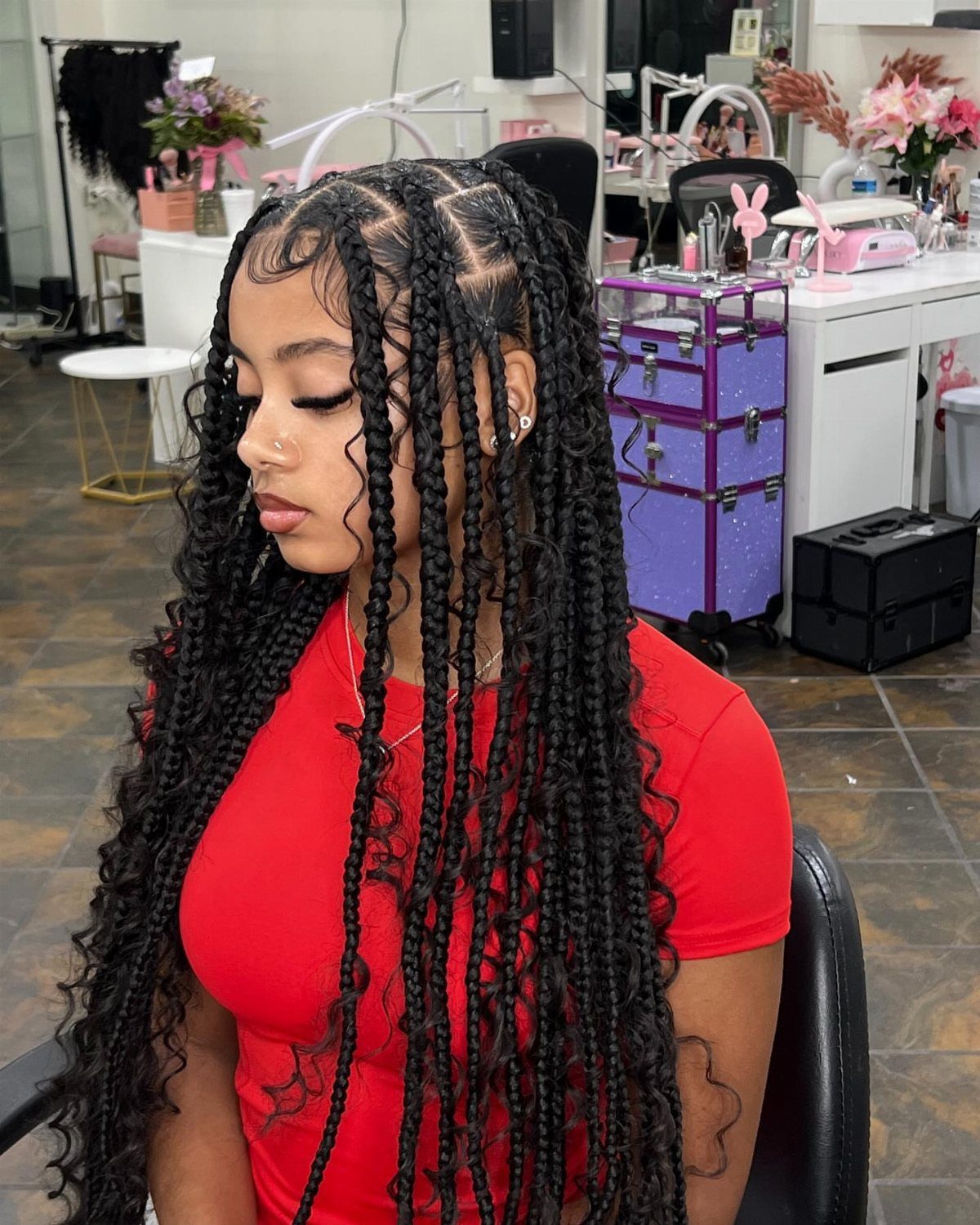Woman wearing long, thick black crochet box braids in a salon
