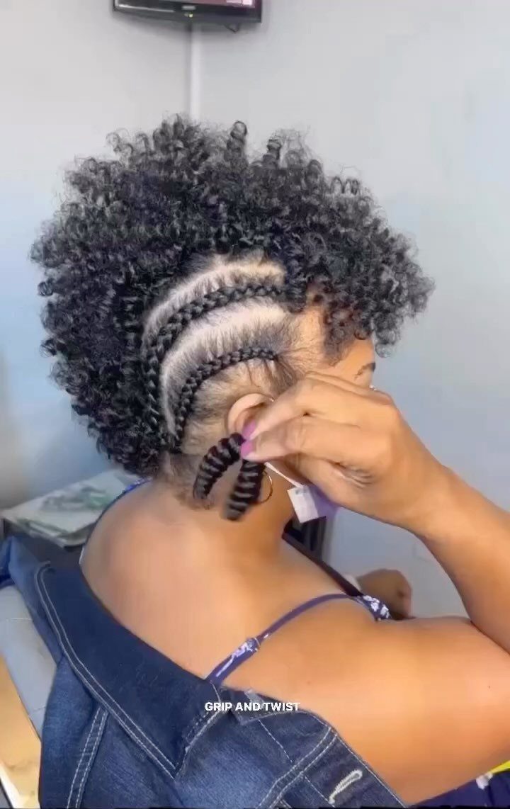 Short curly crochet braids with cornrows being installed along the side of a woman’s head