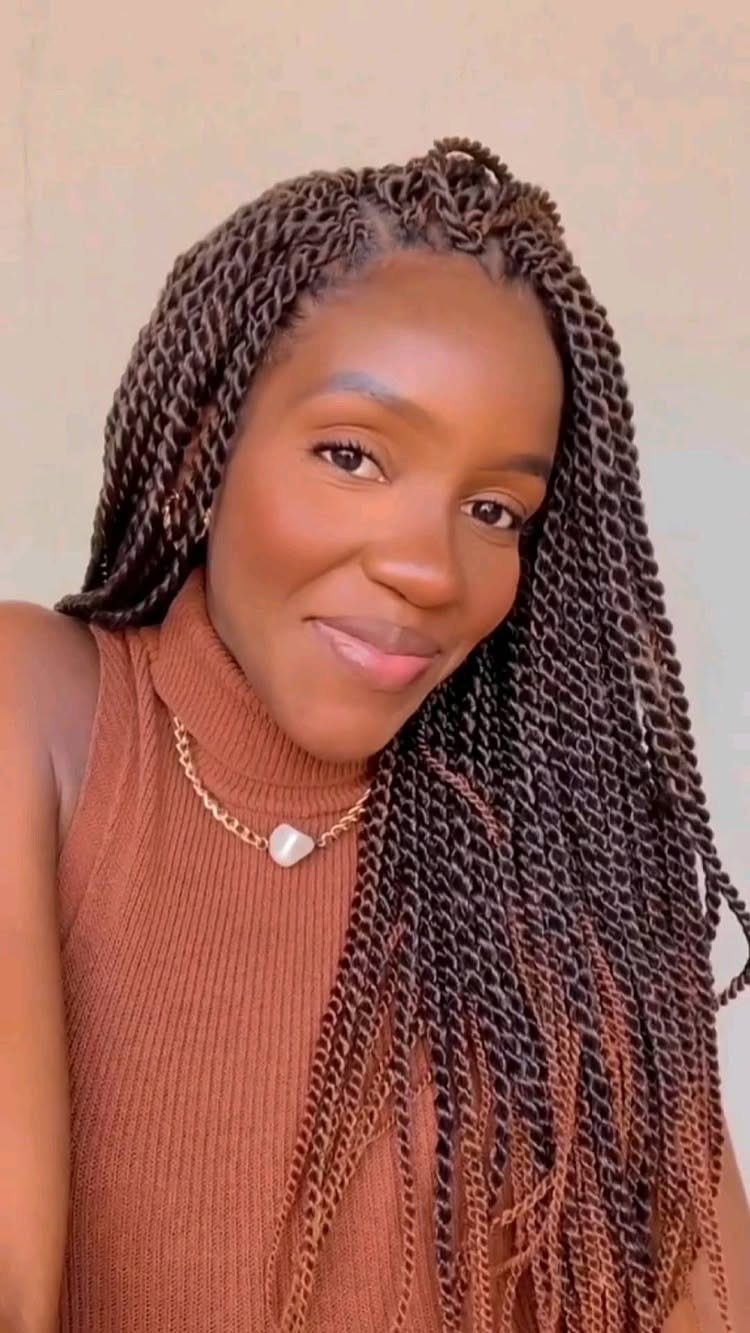Woman with long dark rope-like crochet twists and a side part