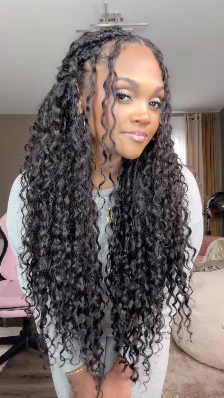 Woman with long goddess locs and loose curly ends posing indoors