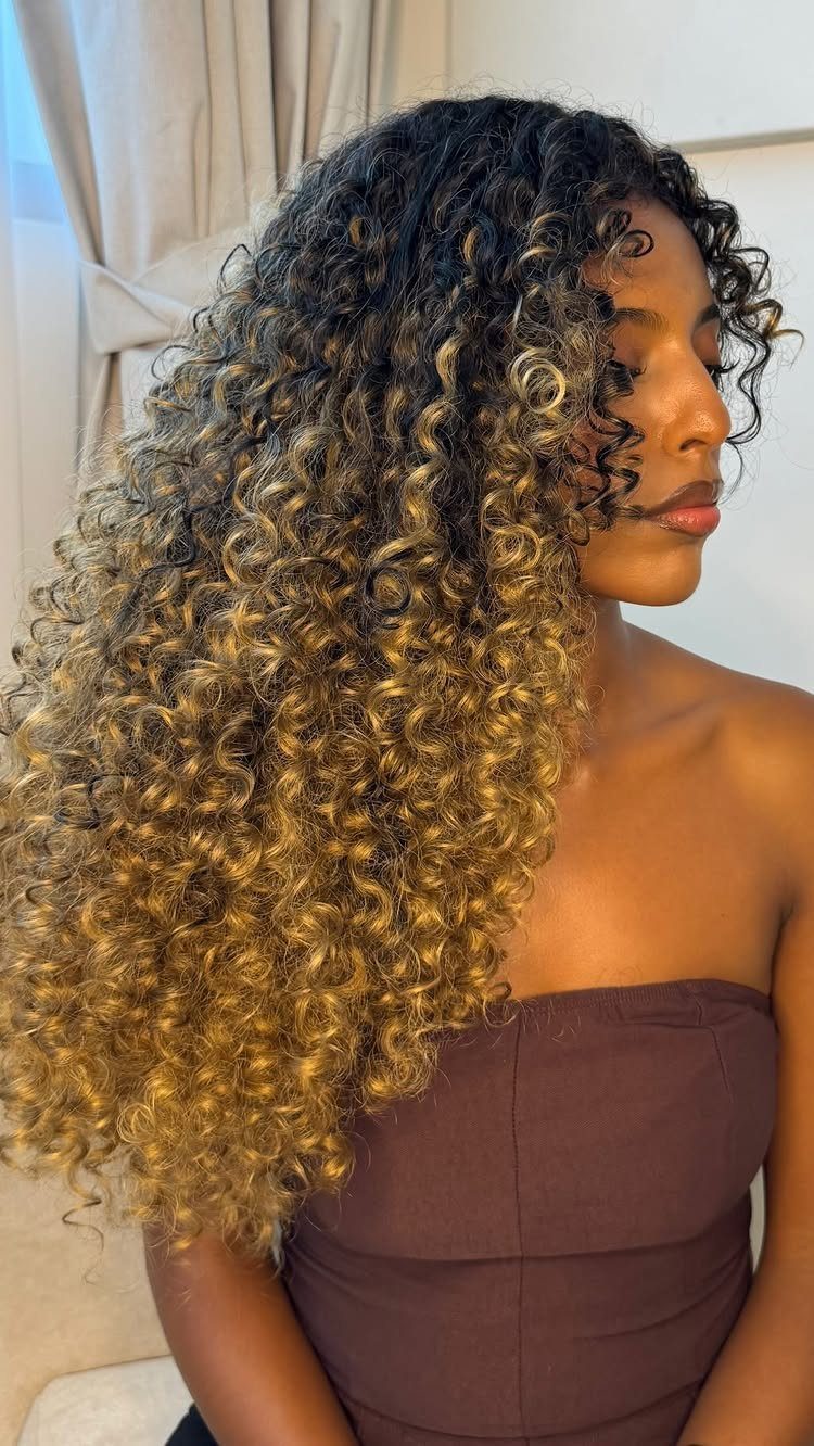 Woman displaying long ombre crochet curls fading from black to golden brown