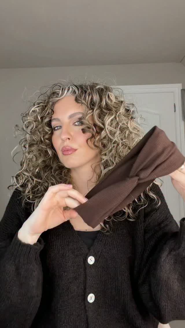 Woman showing high-volume layered curls around her face indoors