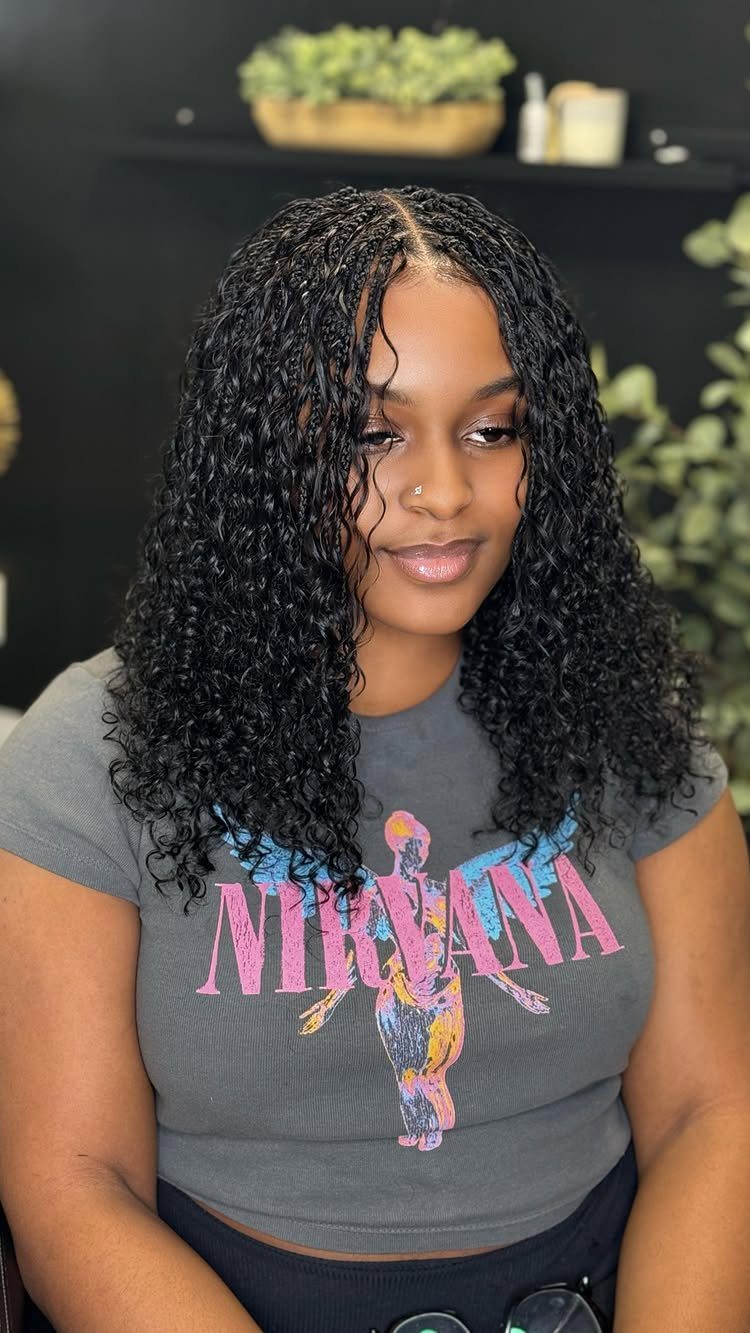 Woman wearing long dark braids with loose curls cascading around her shoulders