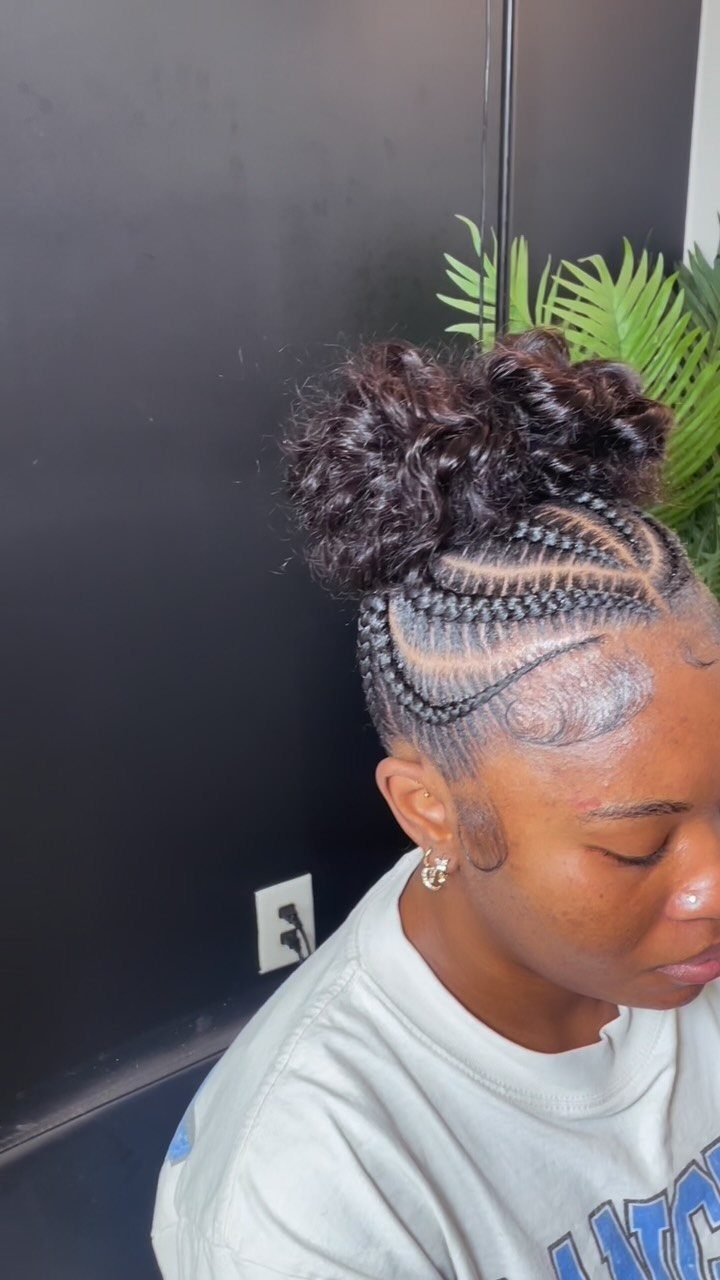 Cornrows gather into a large curly bun with small curls at the hairline