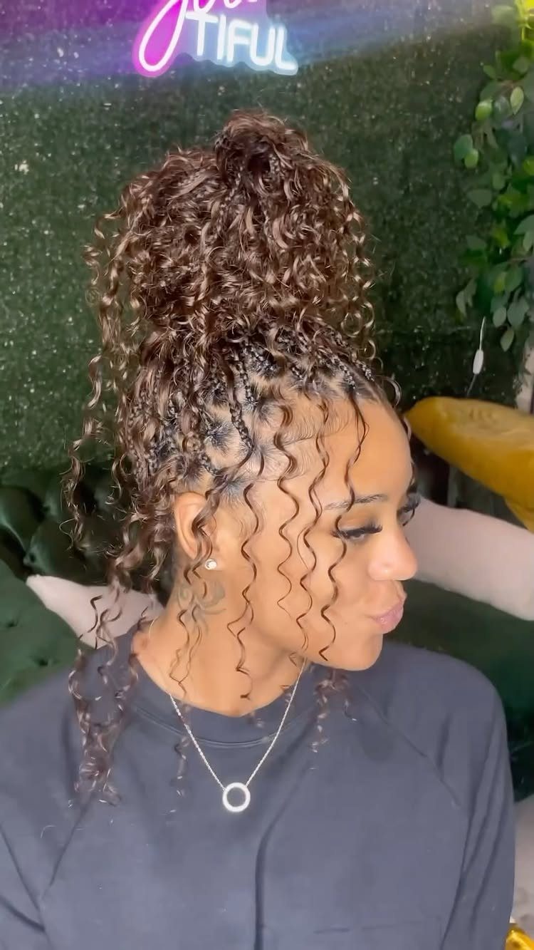 Woman with scalp braids gathered into a high bun of curls