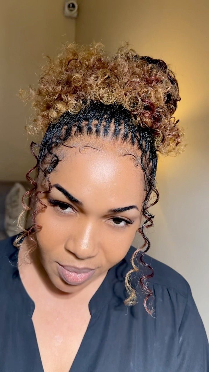 Person wearing braids with short curly face-framing tendrils and a curly bun