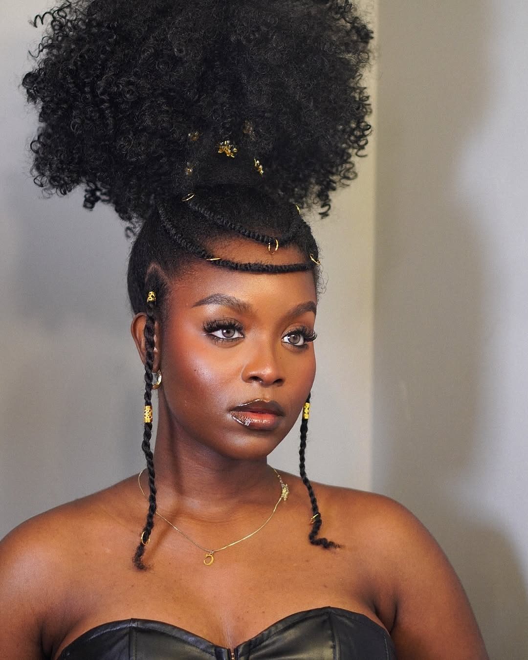 Woman wearing tribal braids gathered into a voluminous curly high bun