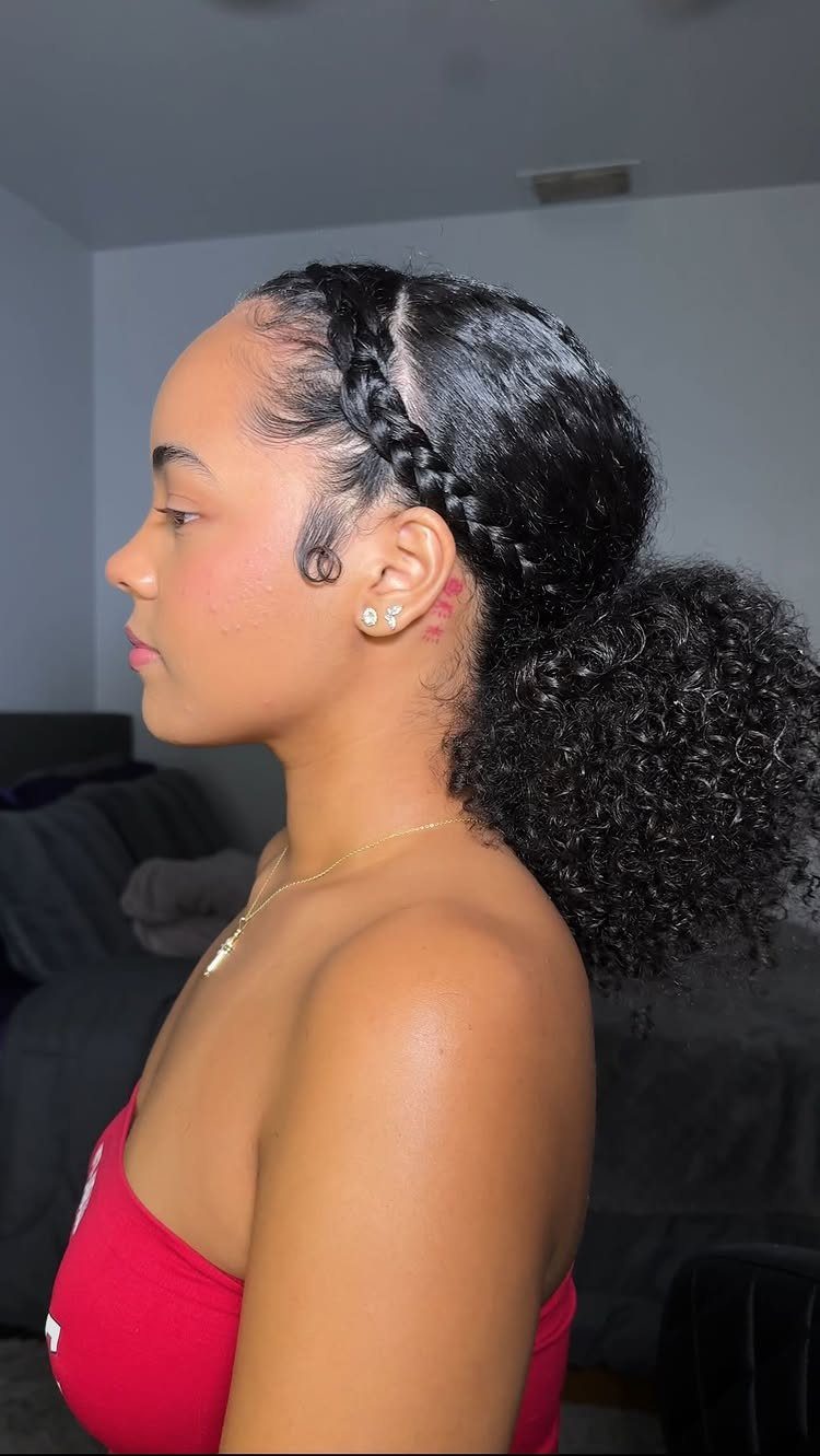 Woman wearing a high curly ponytail with a braid along her hairline