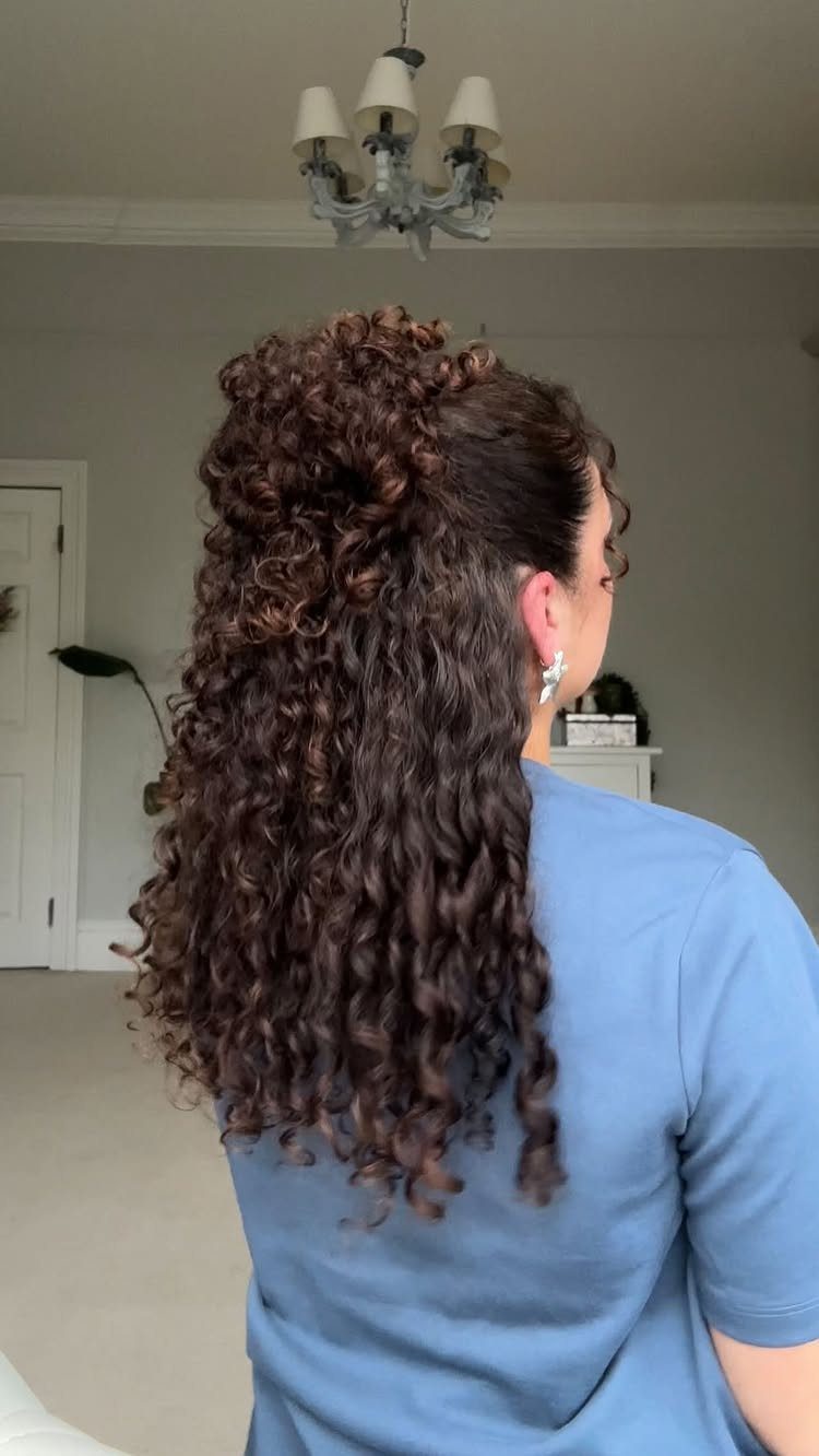 Long curly hair half-up, half-down, with gathered curls at the crown