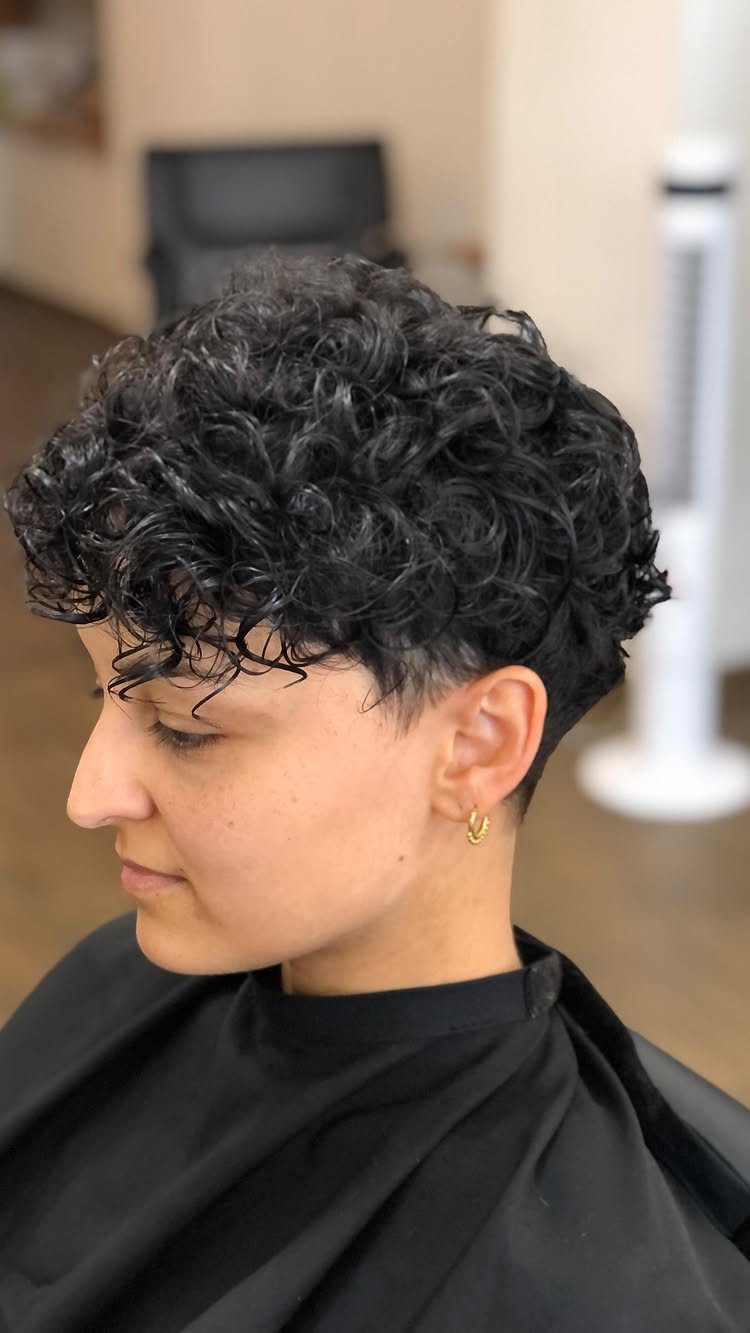Short-haired person showing dense curly top and closely cropped sides