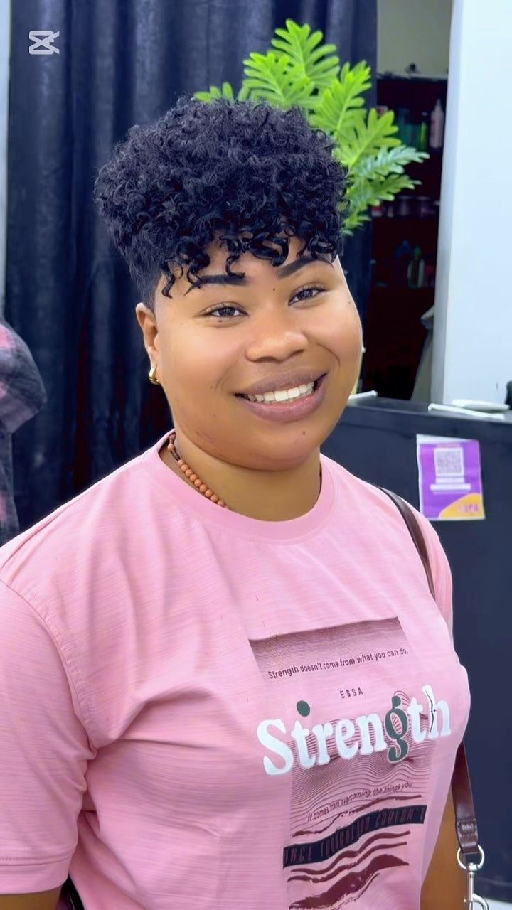 Smiling person showing short curly top fade hairstyle with closely tapered sides