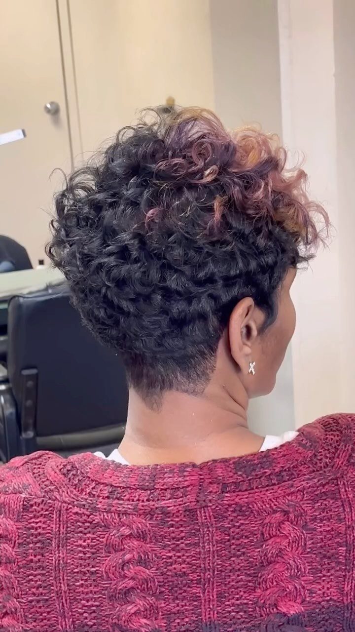 Short curly pixie cut with dark curls, mauve highlights, and a tapered nape