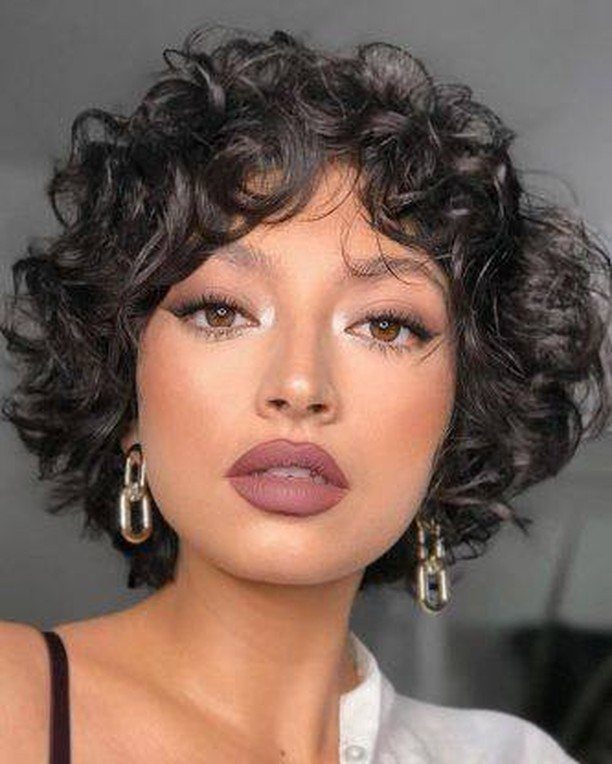 Woman with short shaggy dark curls layered around her face
