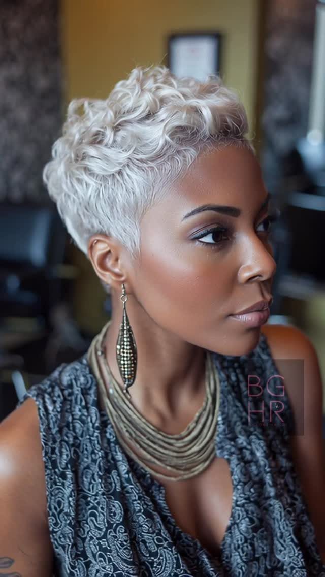 Woman wearing a textured silver curly pixie cut with layered jewelry