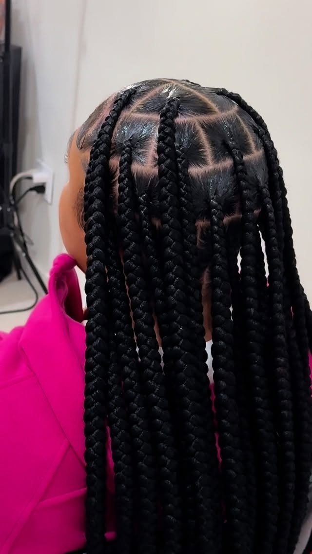 Long box braids arranged in neat rows over a bright pink top