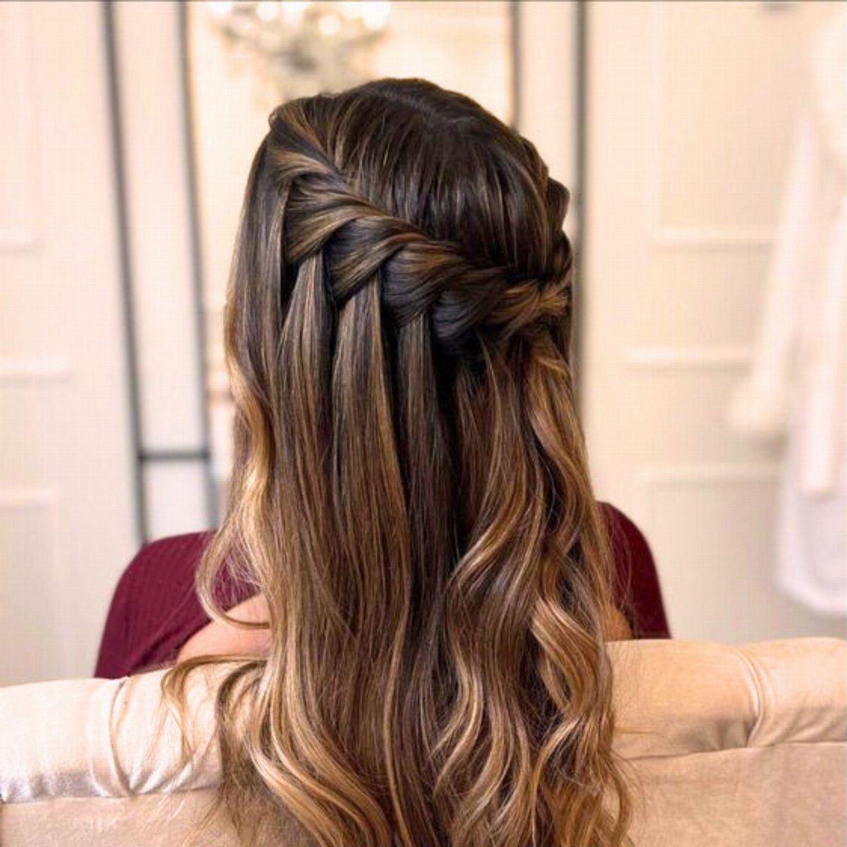 Wavy brown half-up hairstyle with a thick braid woven across the back of the head