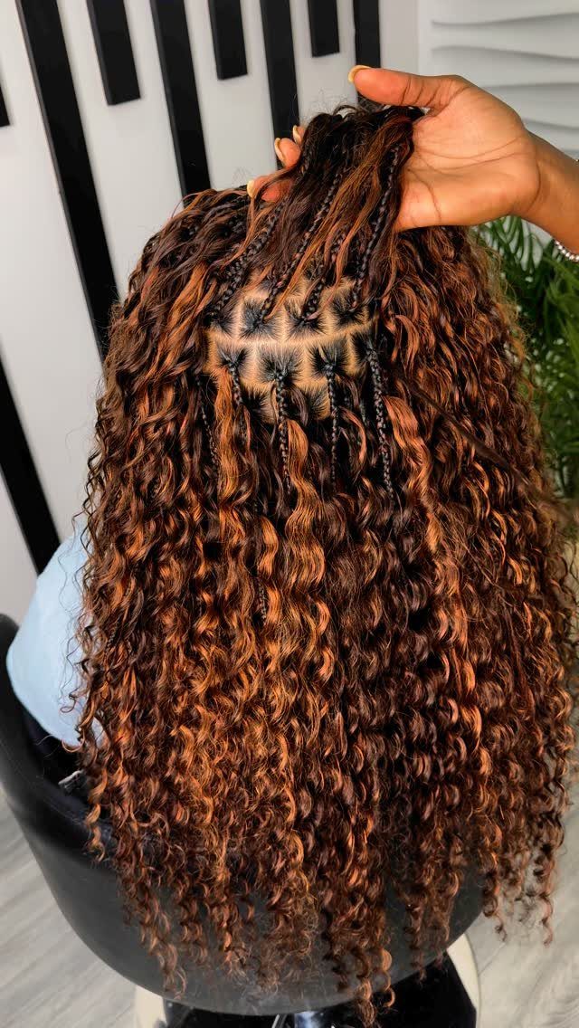 Curly brown crochet braids reveal the braided foundation at the roots