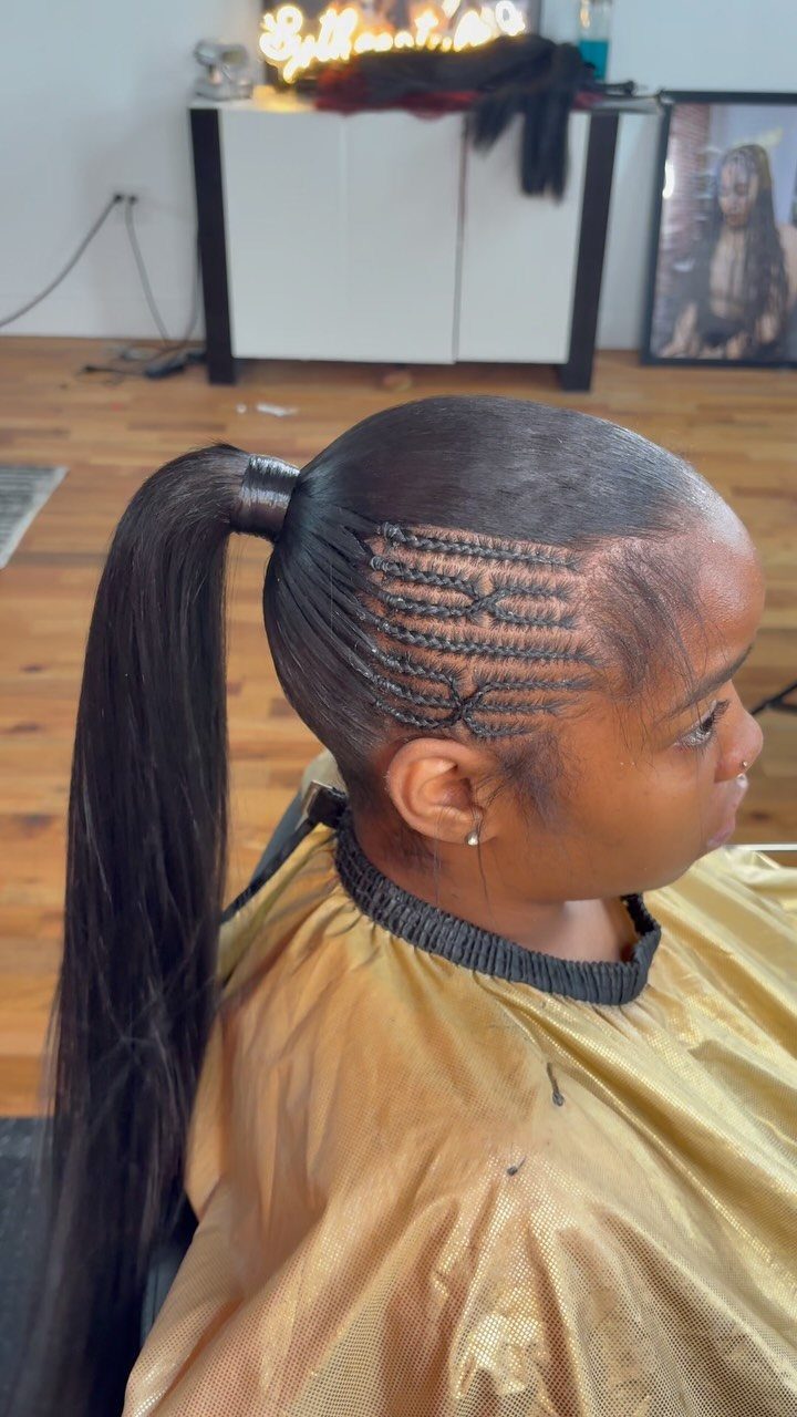Feed-in cornrows gathered into a long high ponytail in a salon