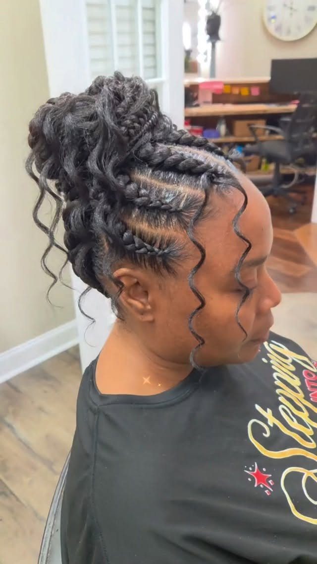 Cornrow braids gathered into a high curly updo with loose tendrils