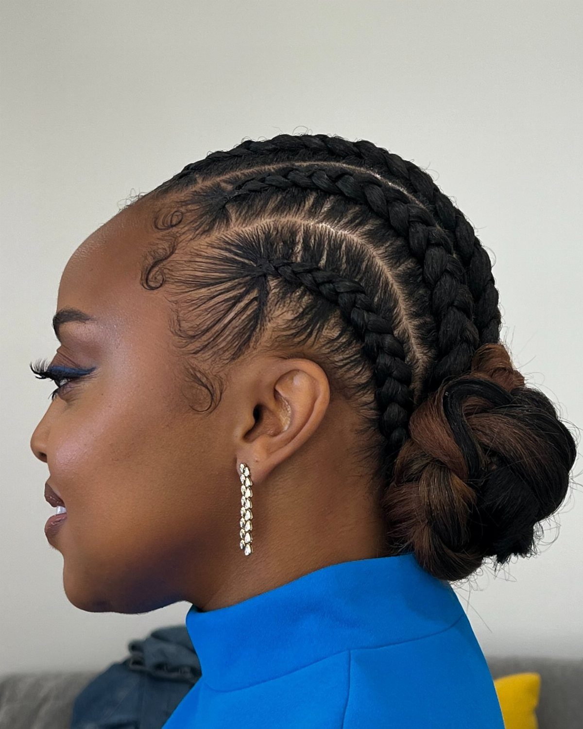 Woman showing thick cornrows gathered into a low bun