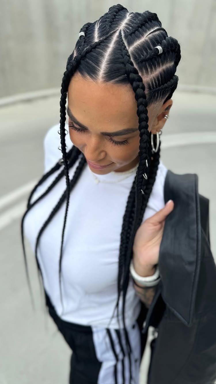 Long black cornrows hang over a white top and black jacket