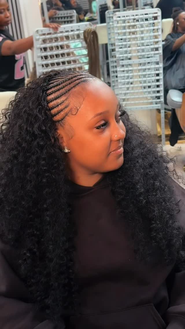 Woman with front feed-in braids blending into long, voluminous curly hair