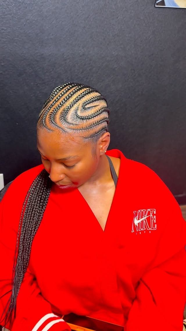 Medium curved cornrows with styled edges and long braids over one shoulder