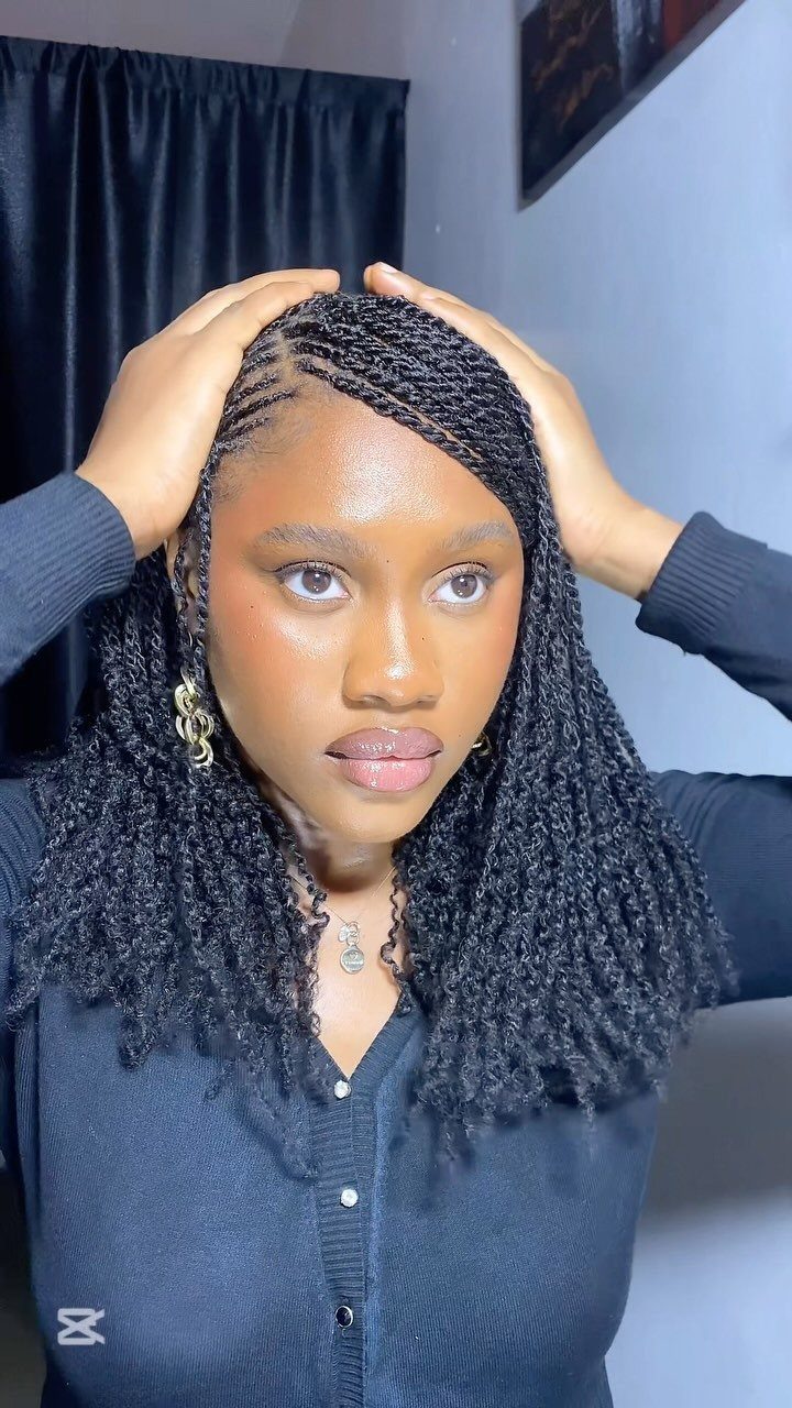 Woman showing fine black braids that end in voluminous curls