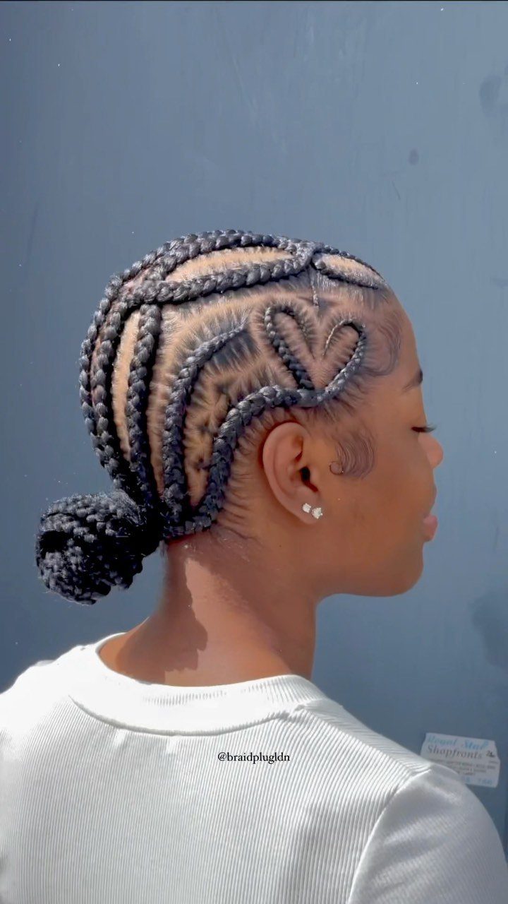 Stitch braids curve around a heart-shaped parting and finish in a low bun