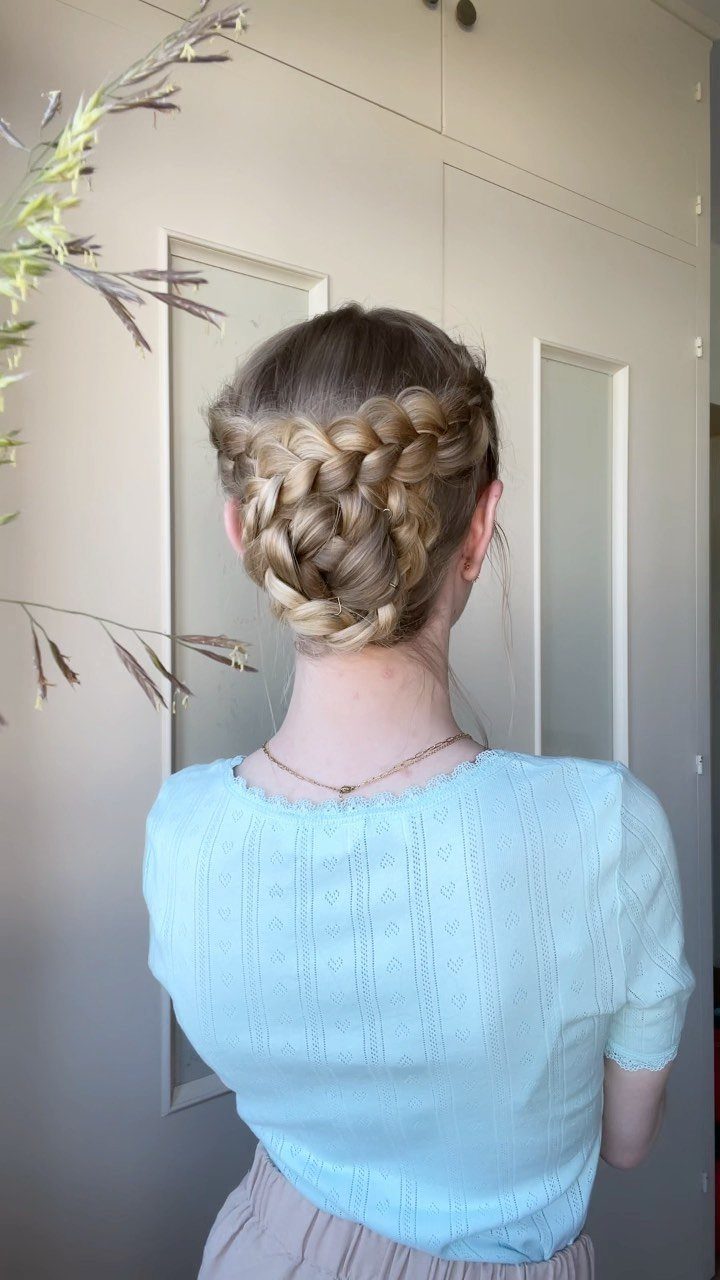Woman showing a diagonal French braid gathered into a low chignon bun