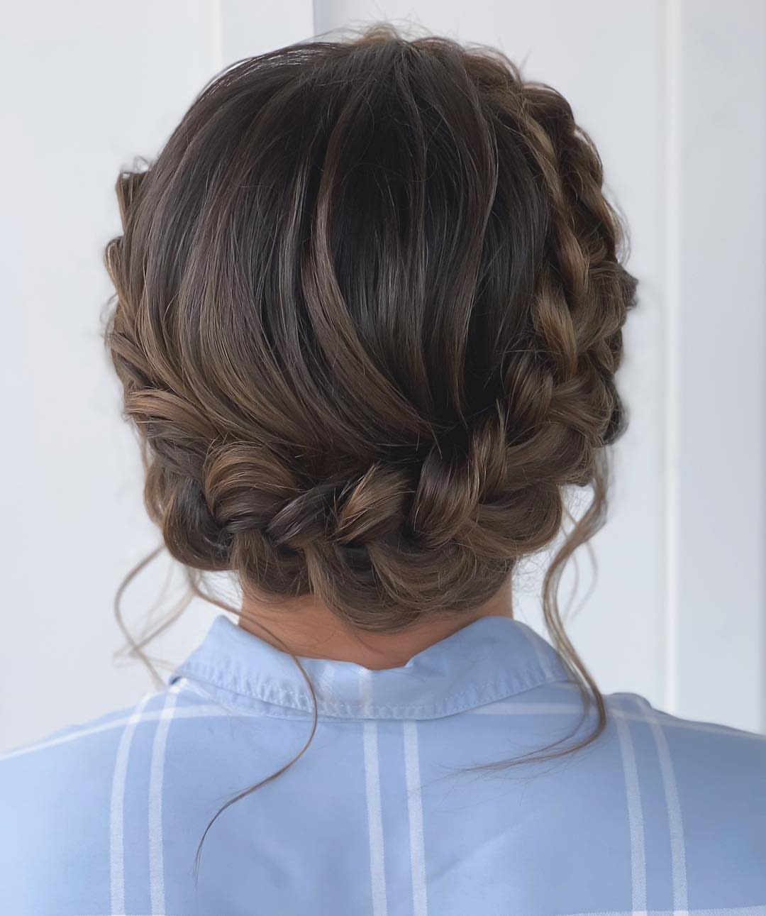 Brown-haired woman wearing a French braid crown gathered into a low bun