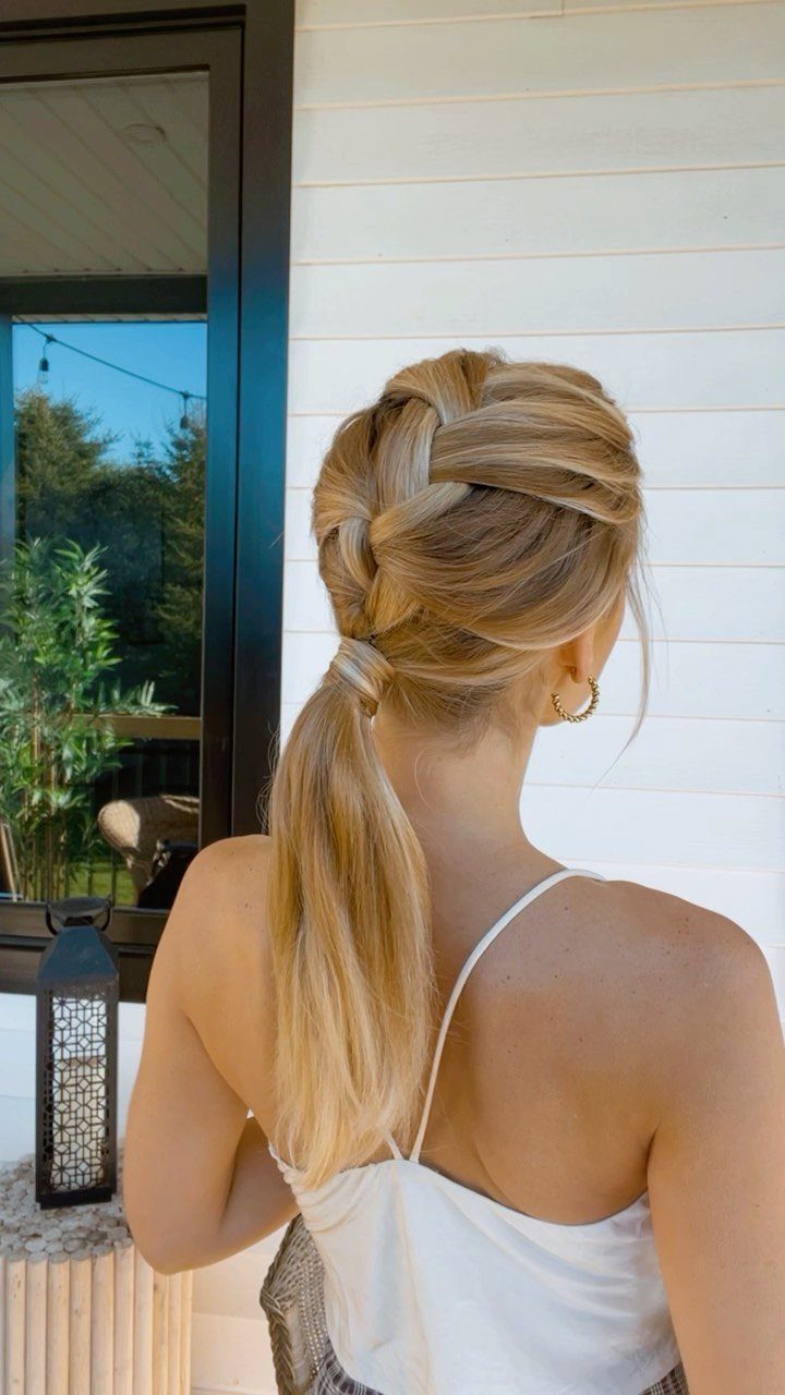 Blonde French braid flowing into a long ponytail on a woman