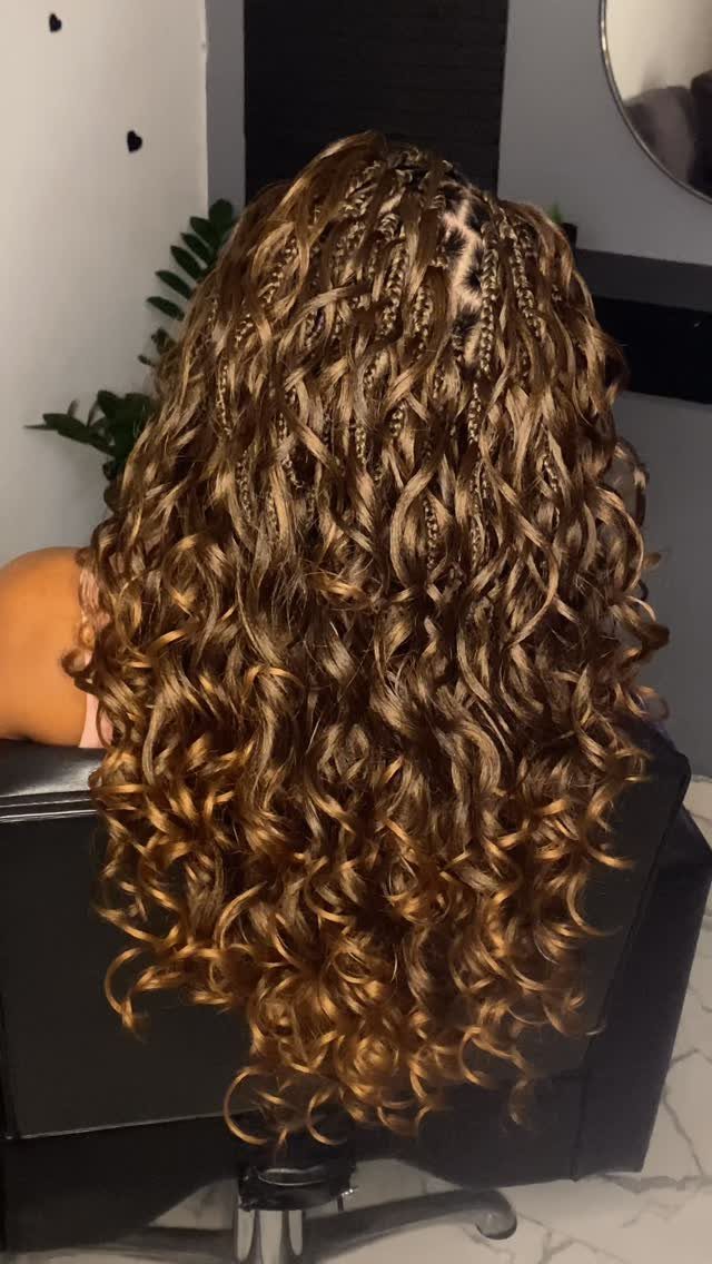Long highlighted curls with narrow French braids woven through the crown