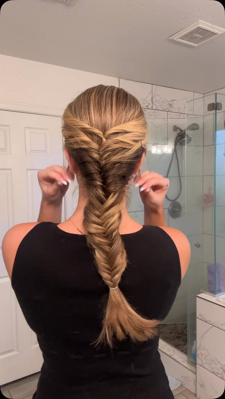 Blonde hair braided from the crown into a thick fishtail down the back