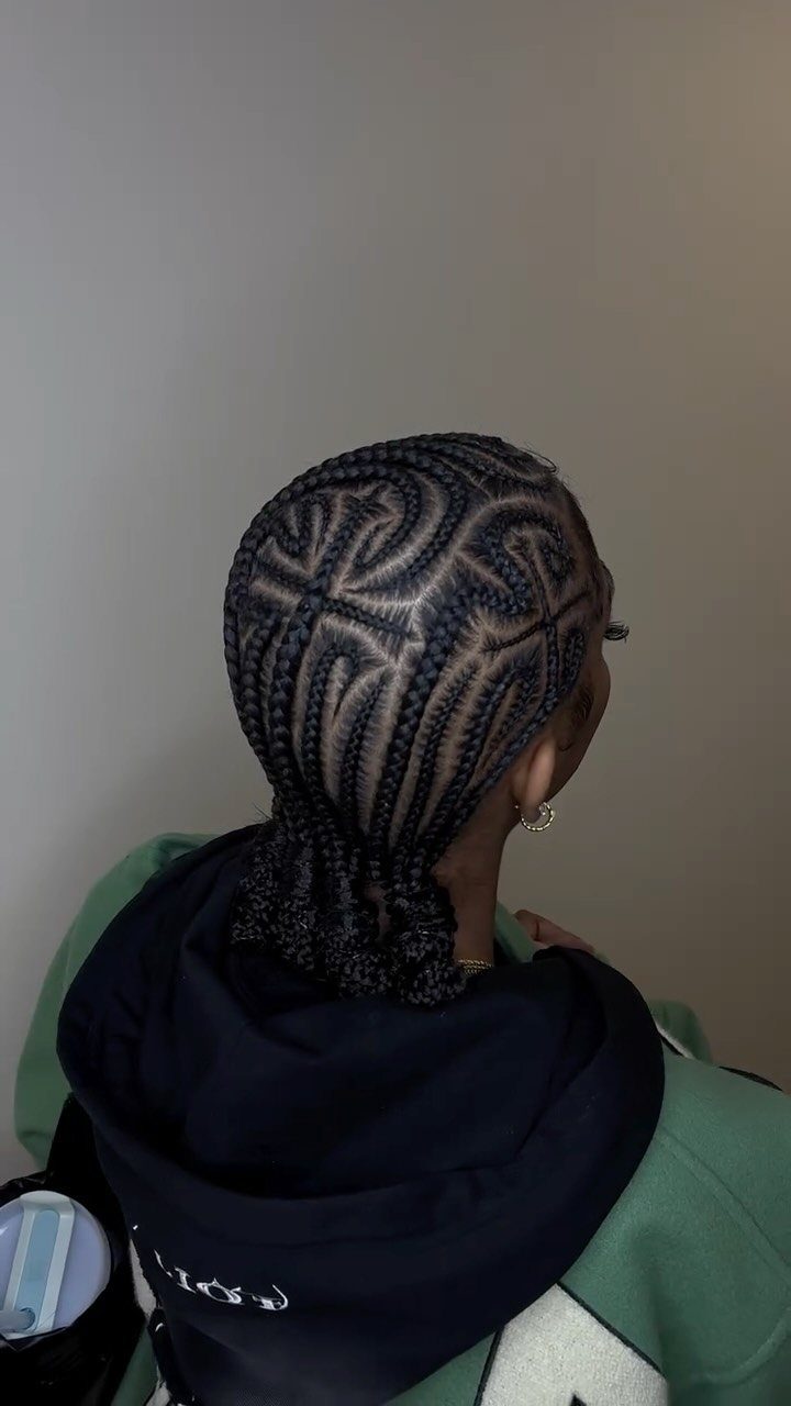 Geometric cornrows feed into larger braids gathered at the nape