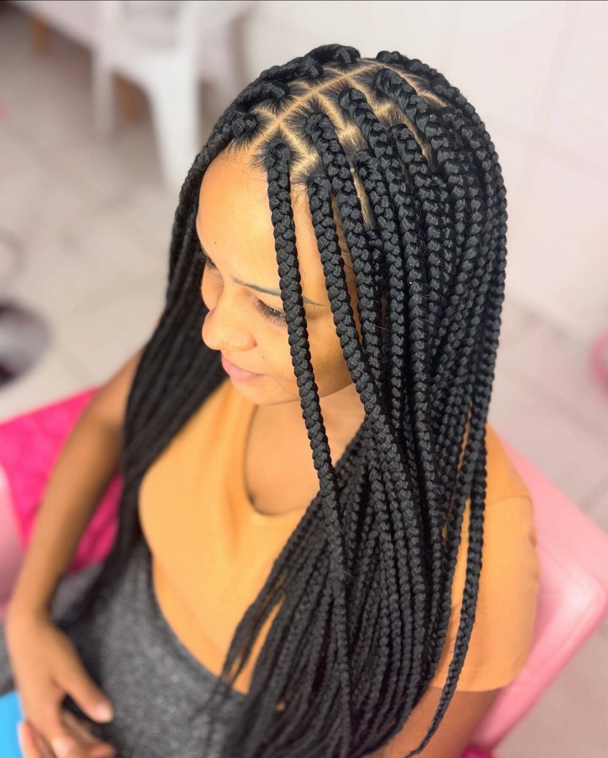 Woman wearing long black box braids with square-section parting