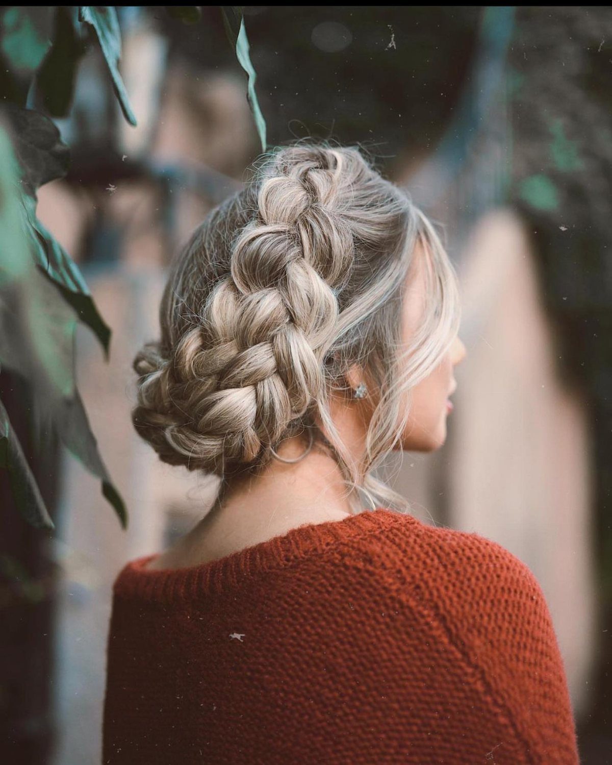 Blonde woman wearing a large braided bun pinned at the back of her head