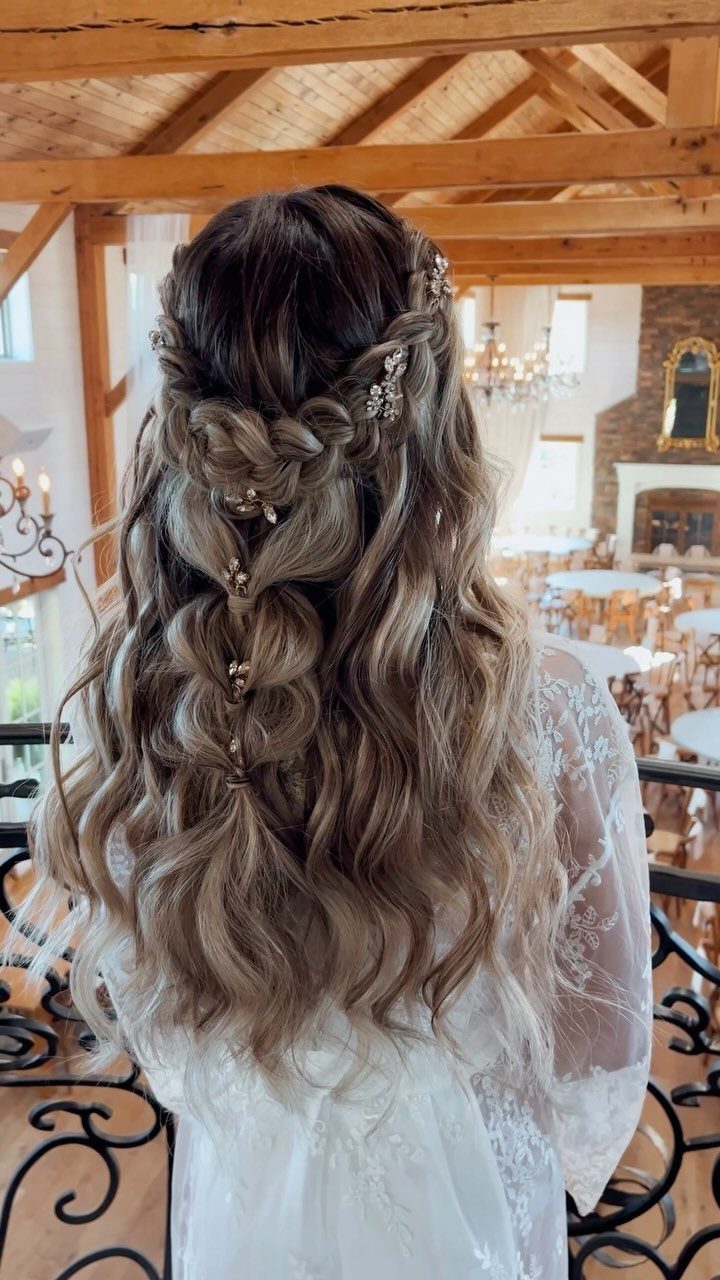 Half-up wavy brown hair with braided sections and decorative pins