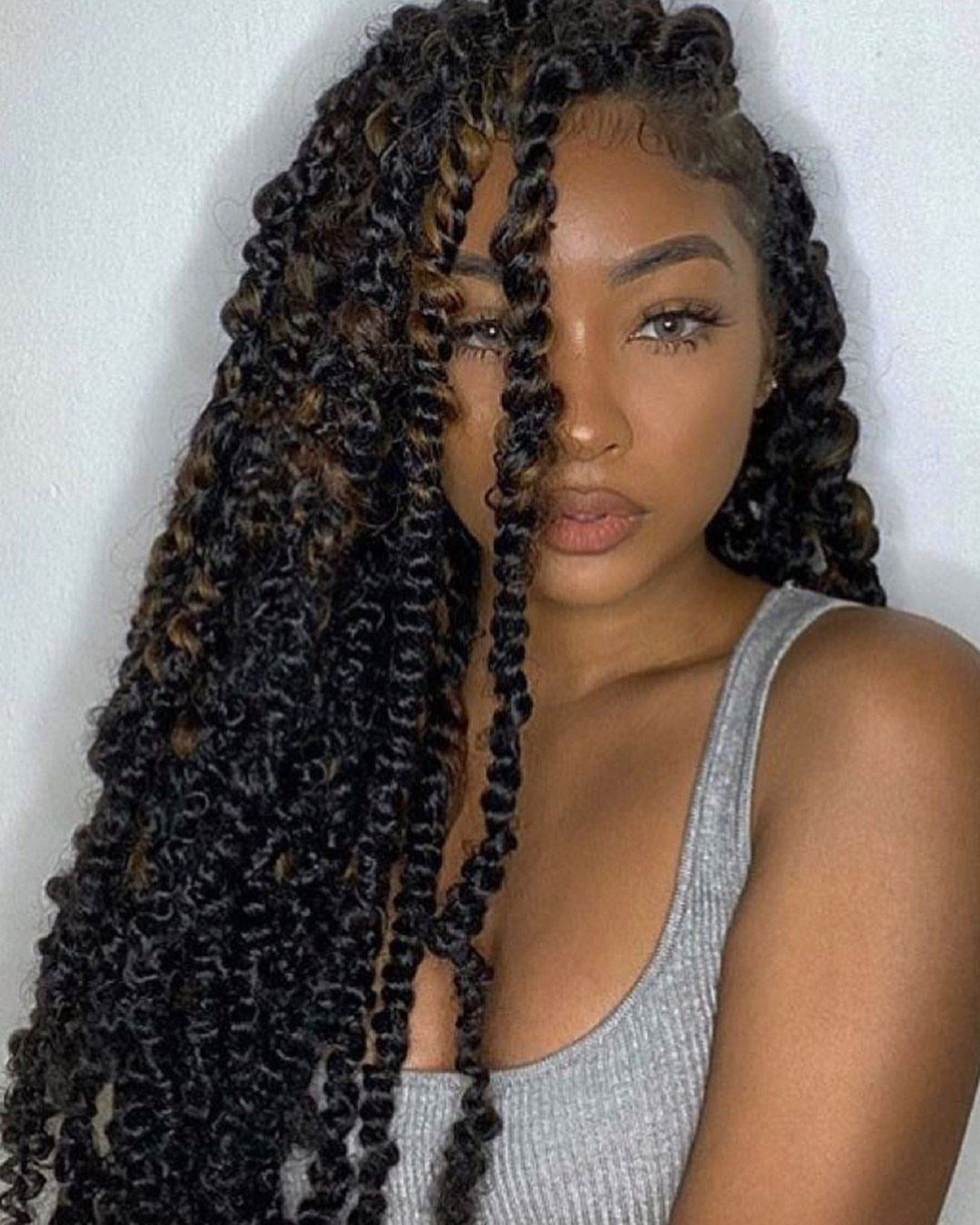 Woman wearing long curly crochet braids with several defined twists