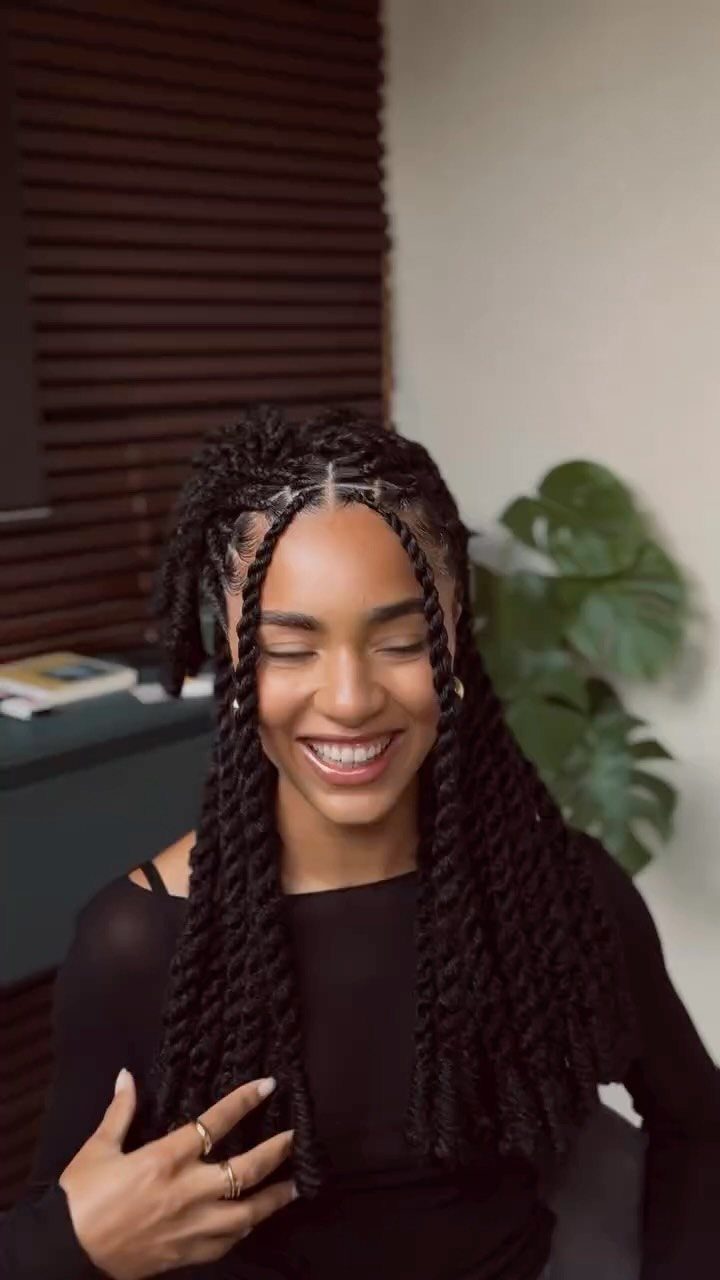 Woman with long dark kinky twists parted at the center