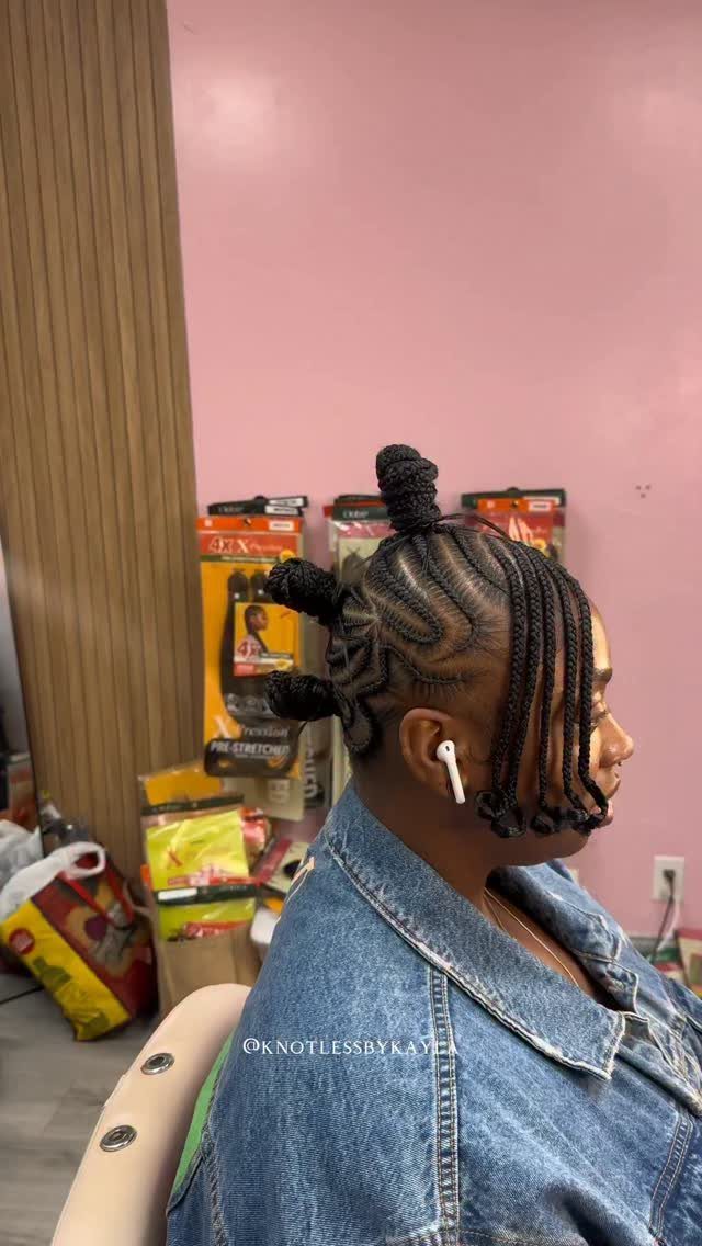 Side-profile person showing raised mohawk-shaped braids with a small top bun