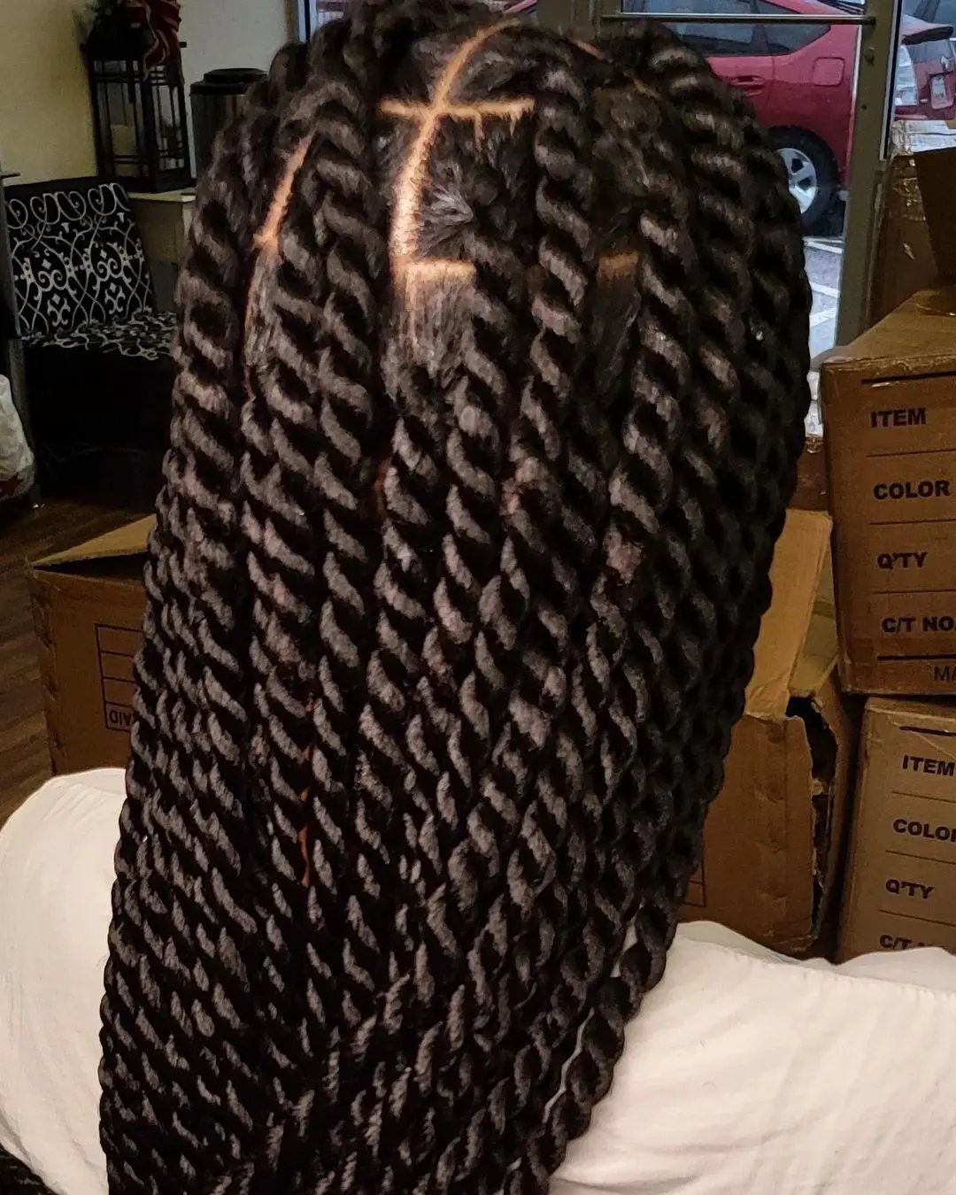 Long black tightly coiled twists arranged in rows on a person’s head