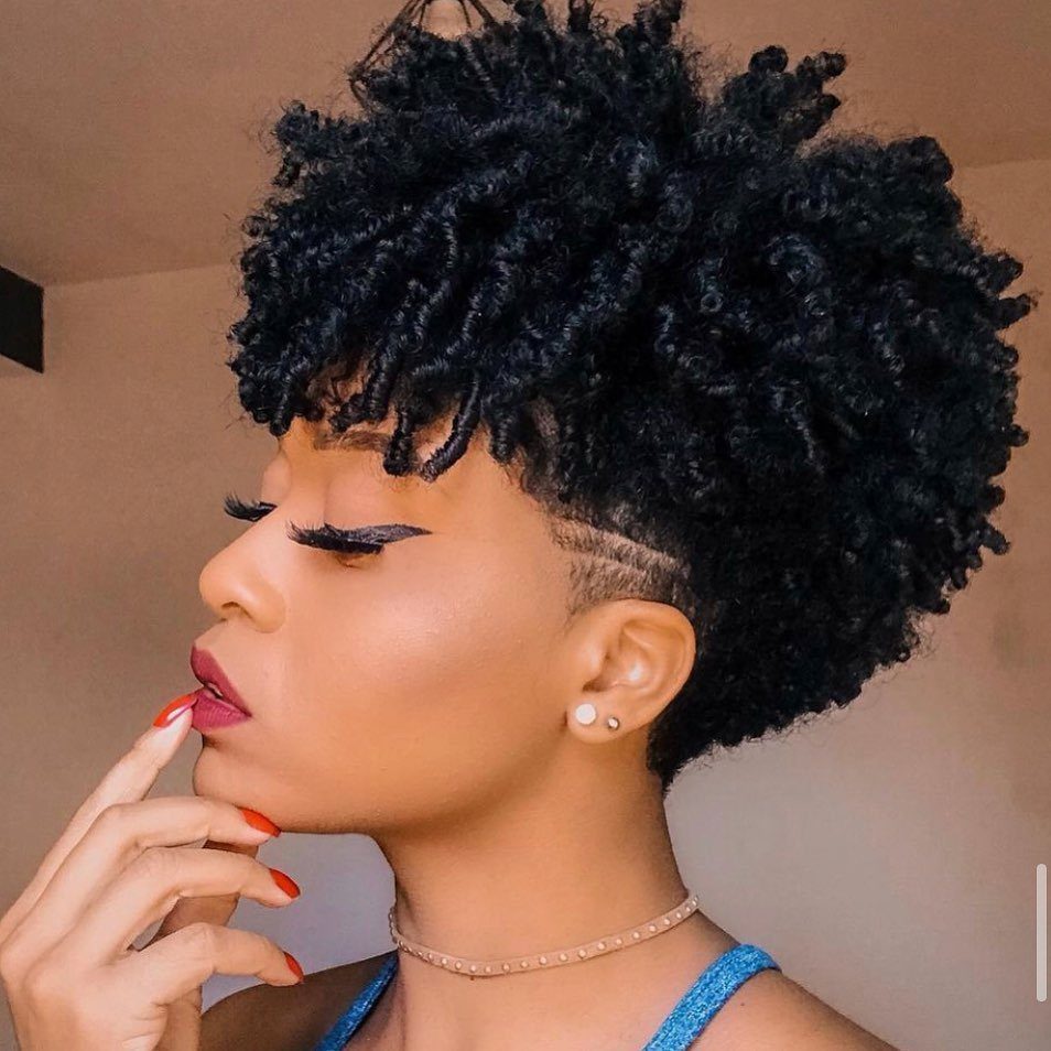 Cropped black ringlets with tapered sides and back on a person in profile