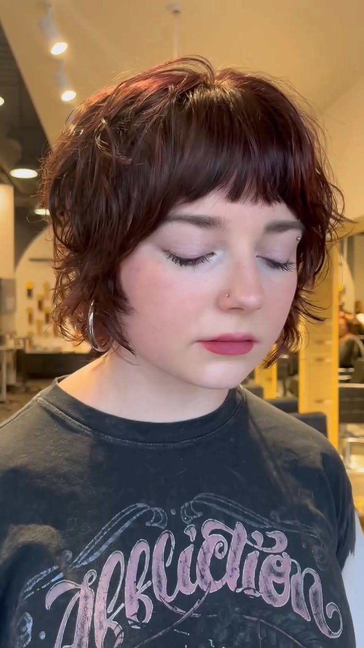 Short layered curly shag with tousled texture and a blunt fringe