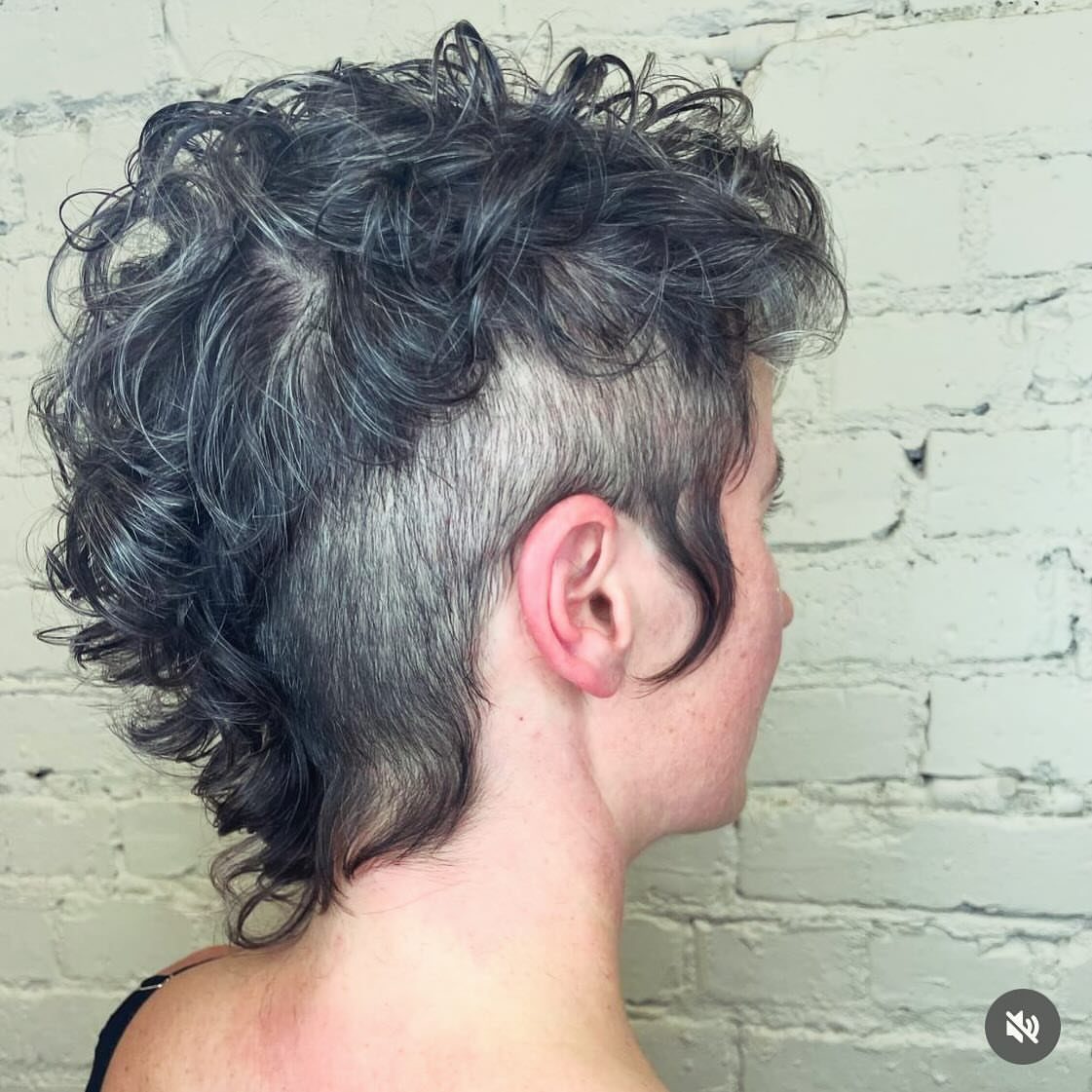 Curly faux hawk with closely shaved sides and a longer curled back