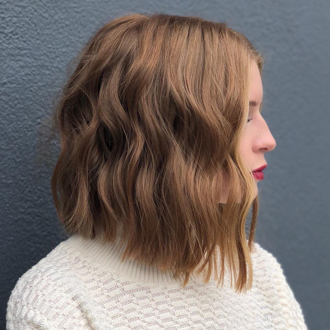 Side profile showing an inverted lob with wavy brown hair and longer front layers