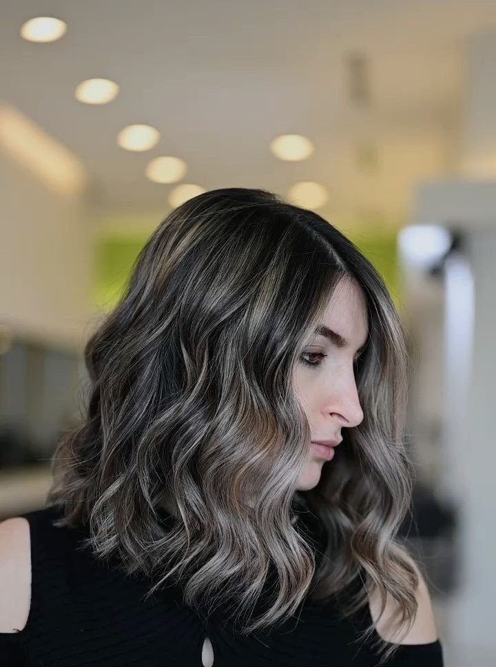 Woman with a thick, shoulder-length wavy bob and long piecey layers