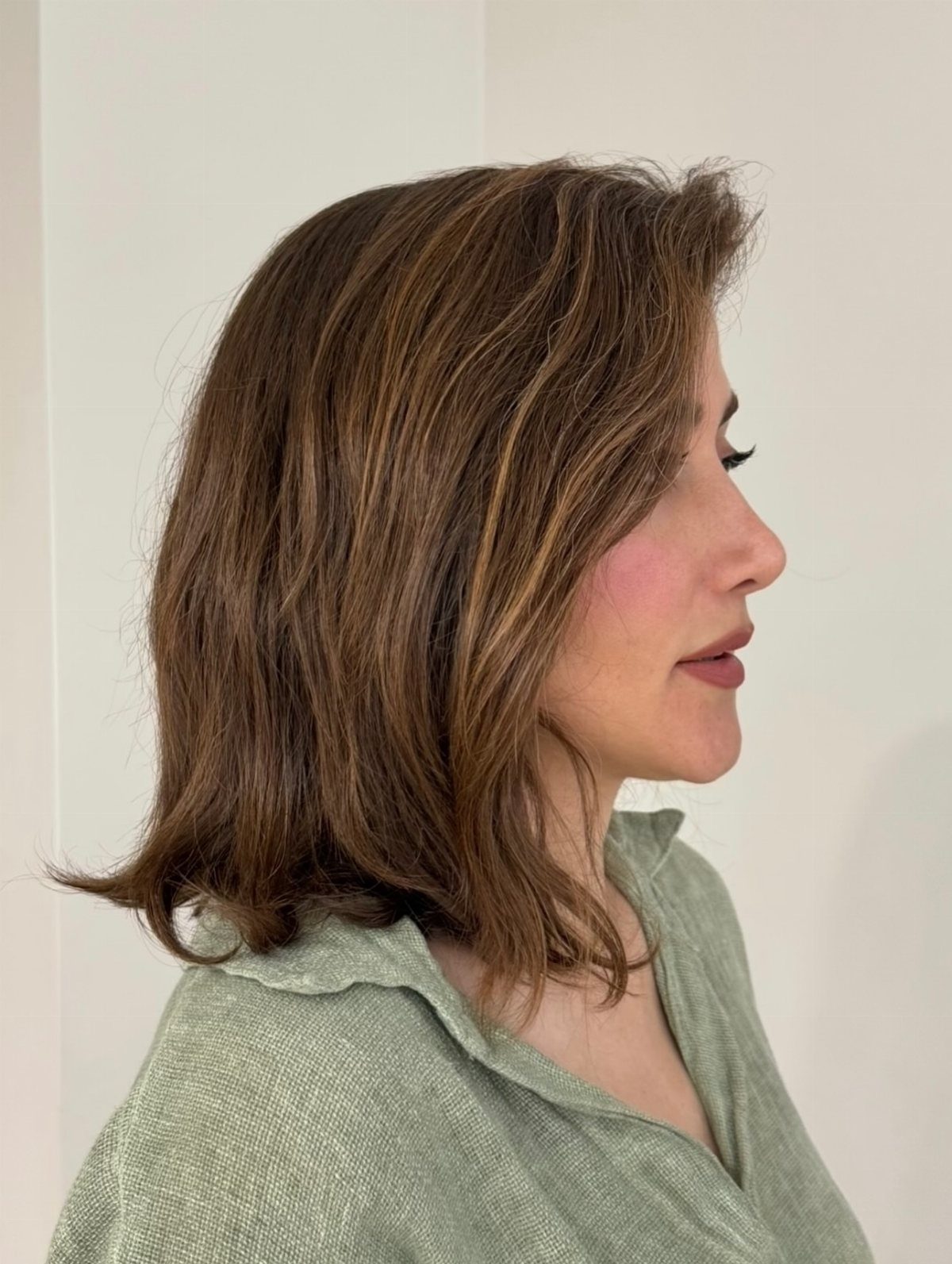 Woman with a wavy brown long bob and subtle lighter highlights